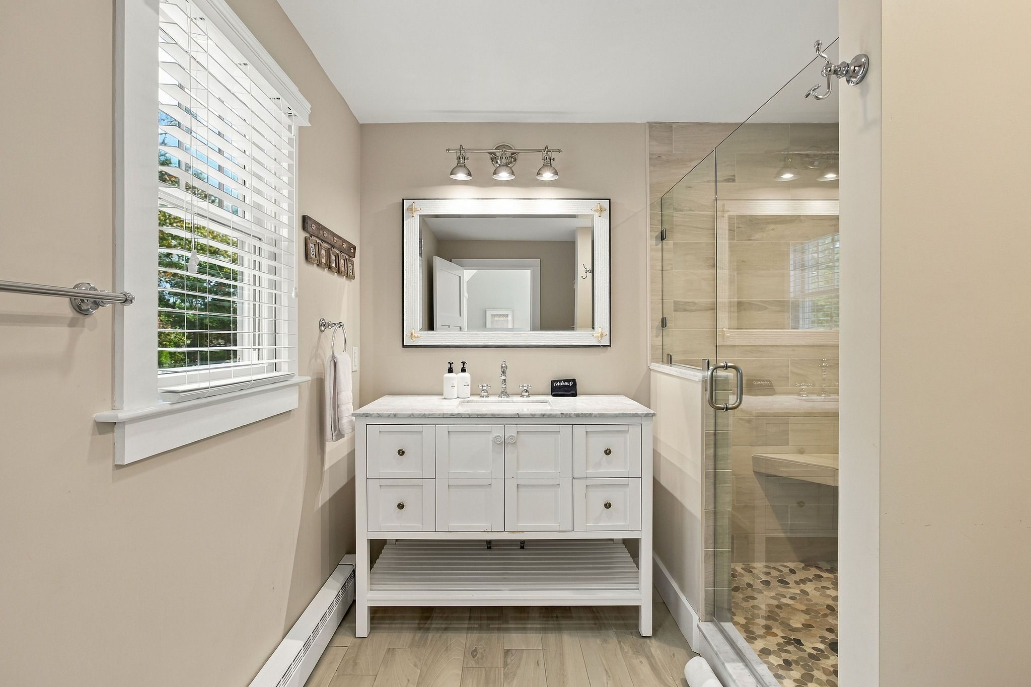 Bright spa-style bathroom with glass walk-in shower and elegant vanity