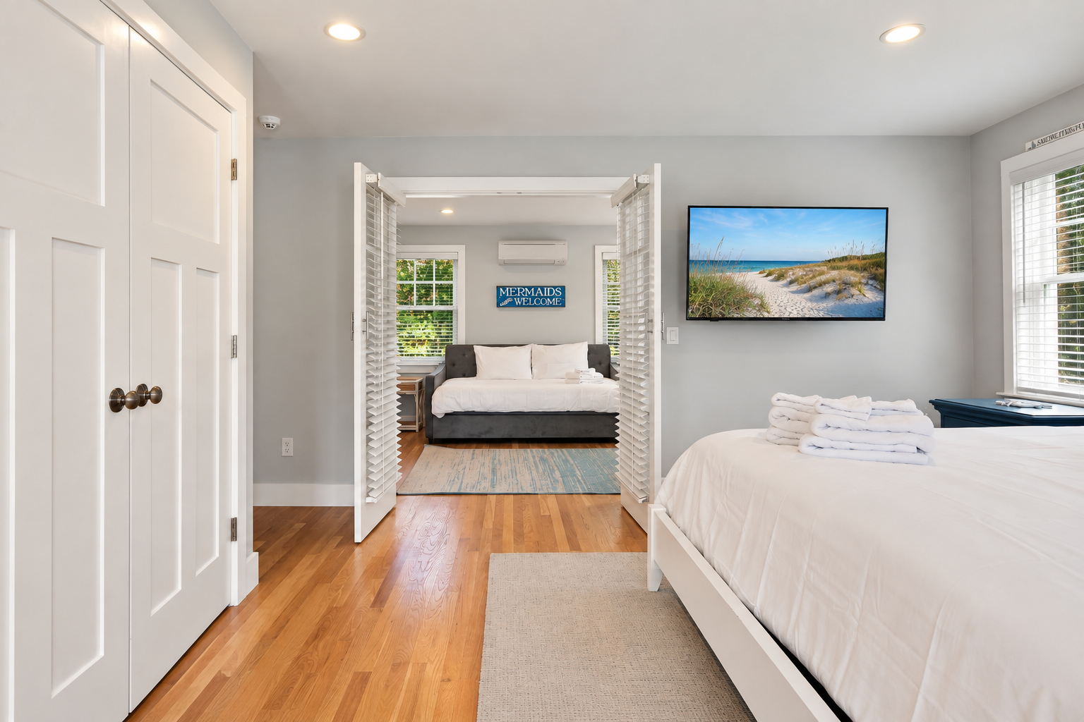 Bright coastal bedroom with French doors and spacious two-room layout