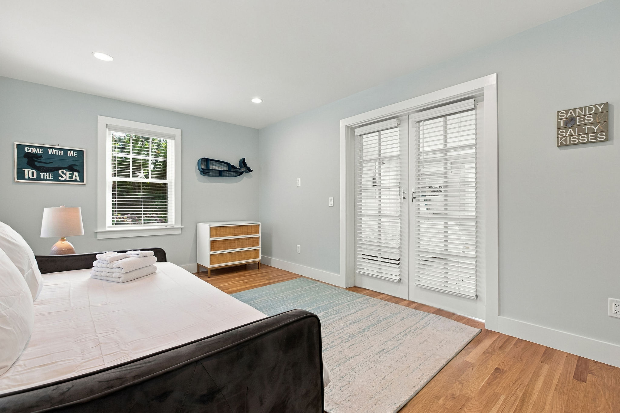 Bright coastal bedroom with French doors and relaxing beachy charm