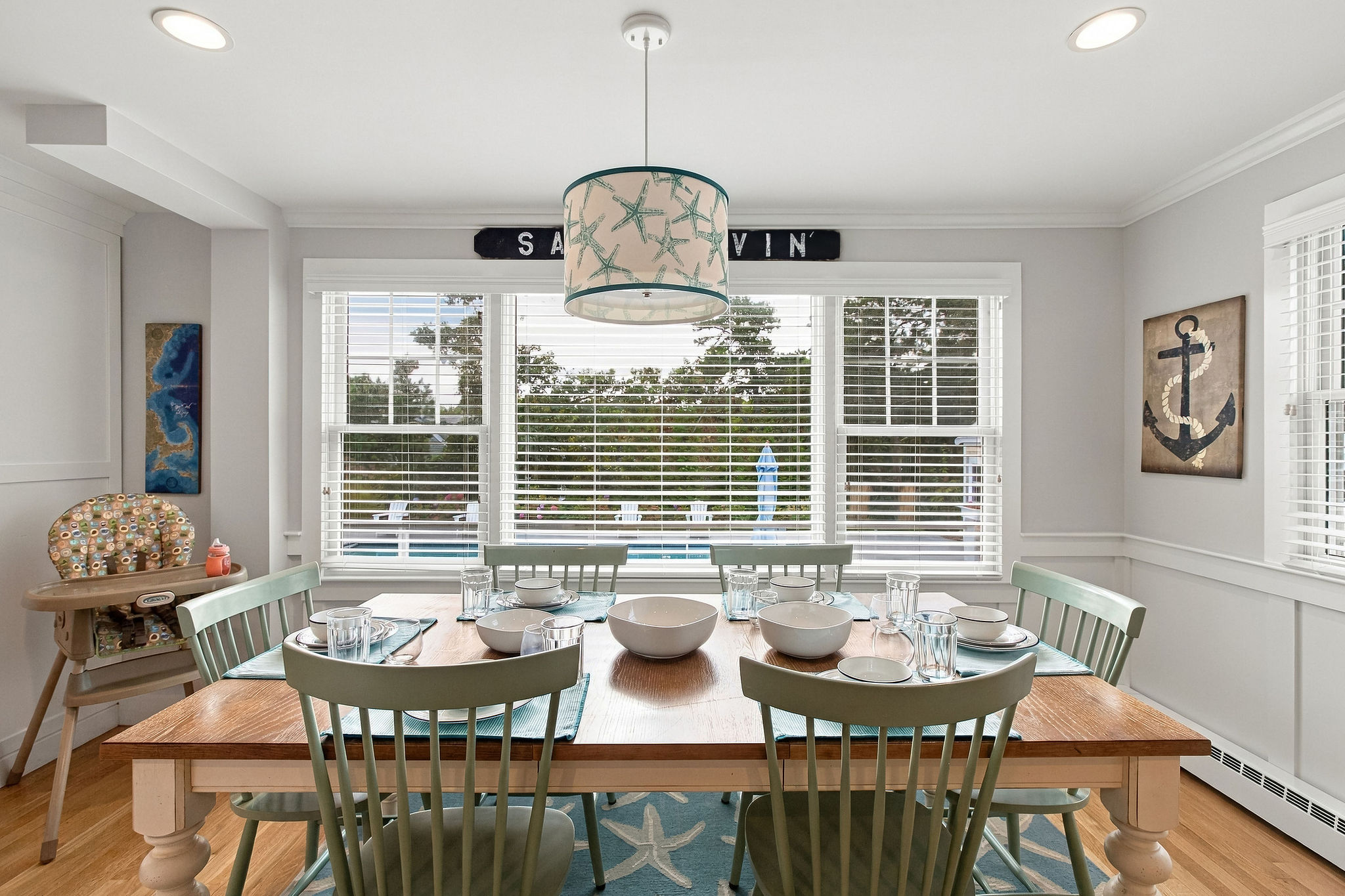Bright coastal dining room with seating for 6 and sunny outdoor views