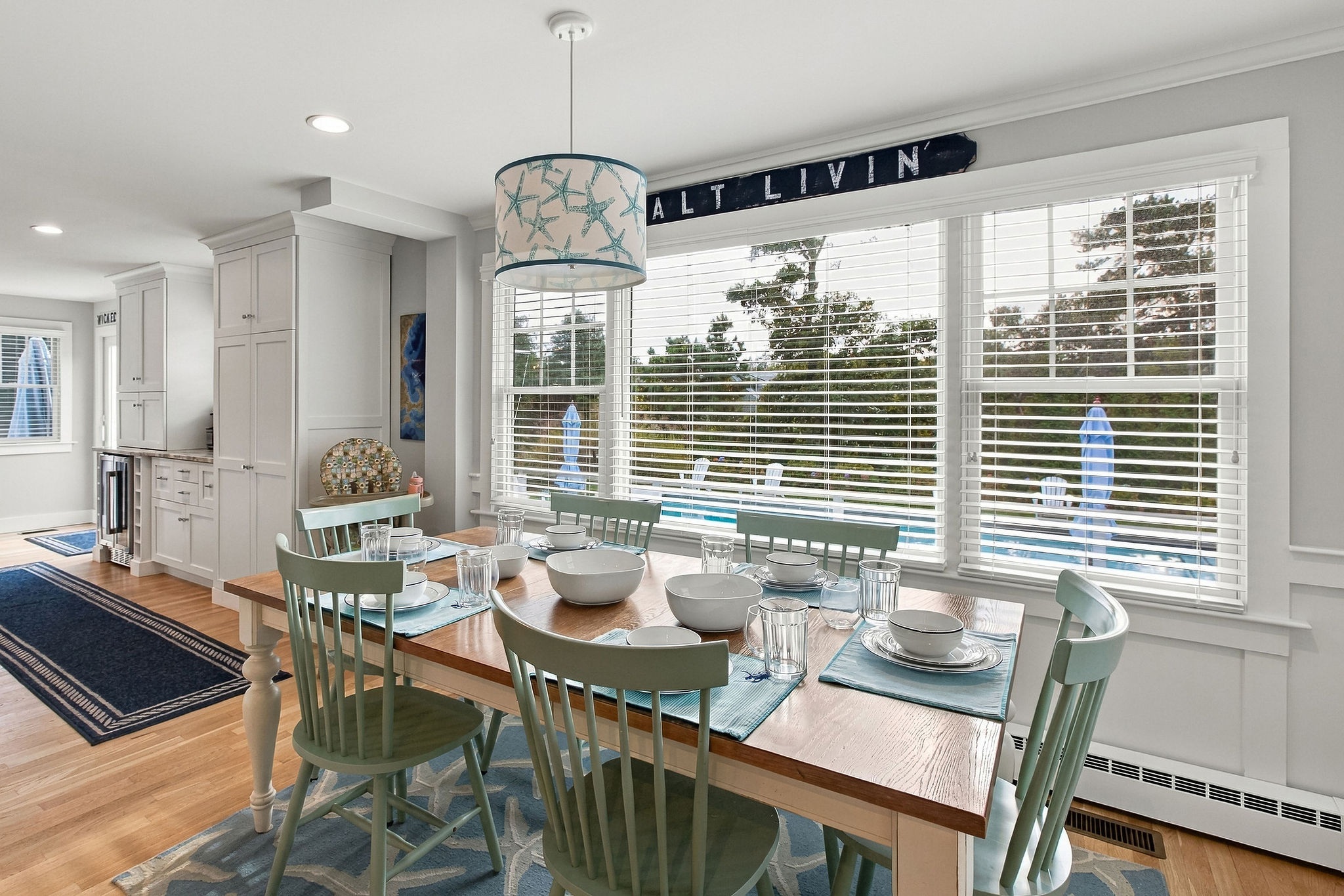 Sunny coastal dining space with pool views and seating for six