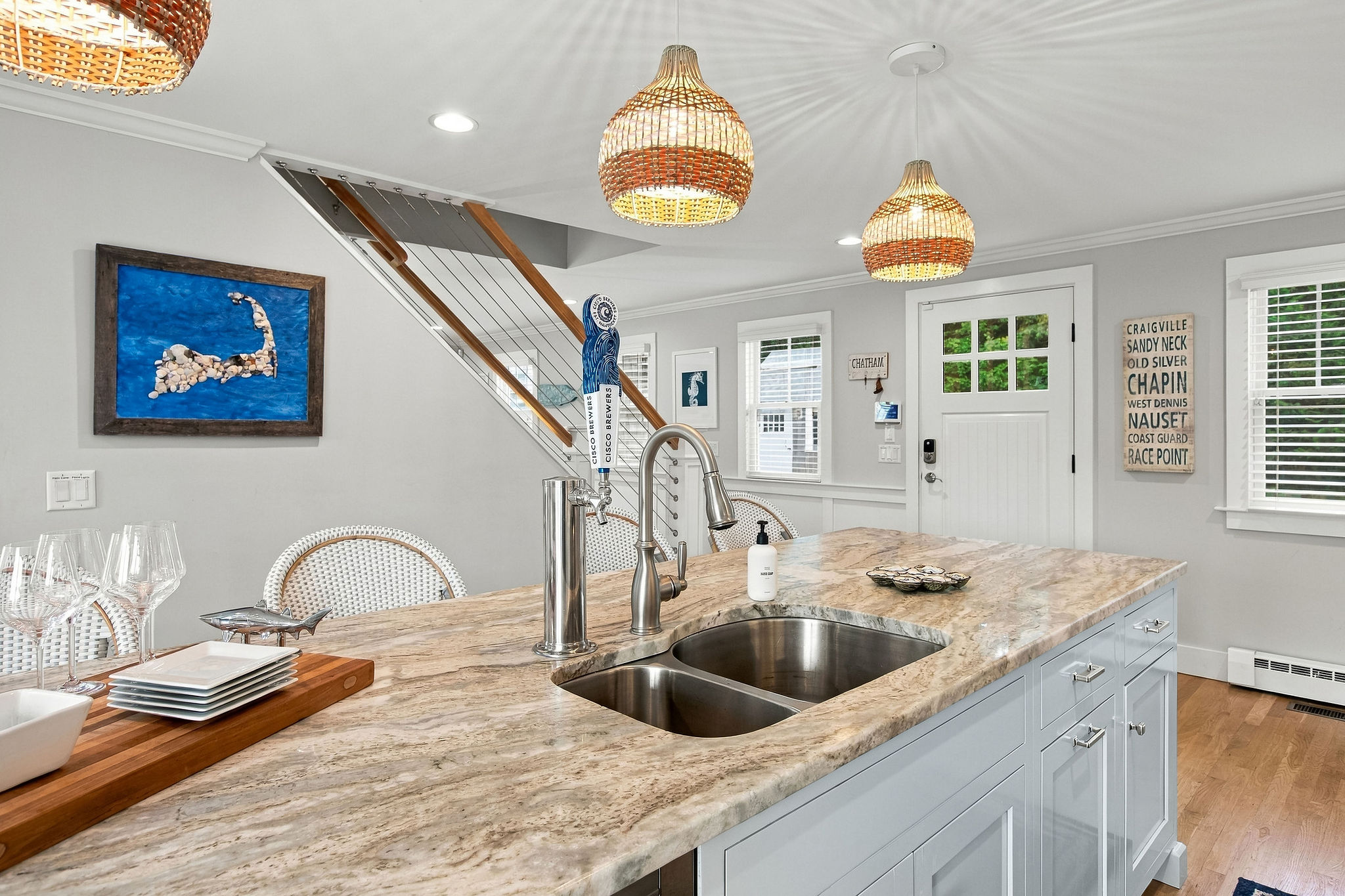 Bright coastal kitchen with oversized island and stylish pendant lighting