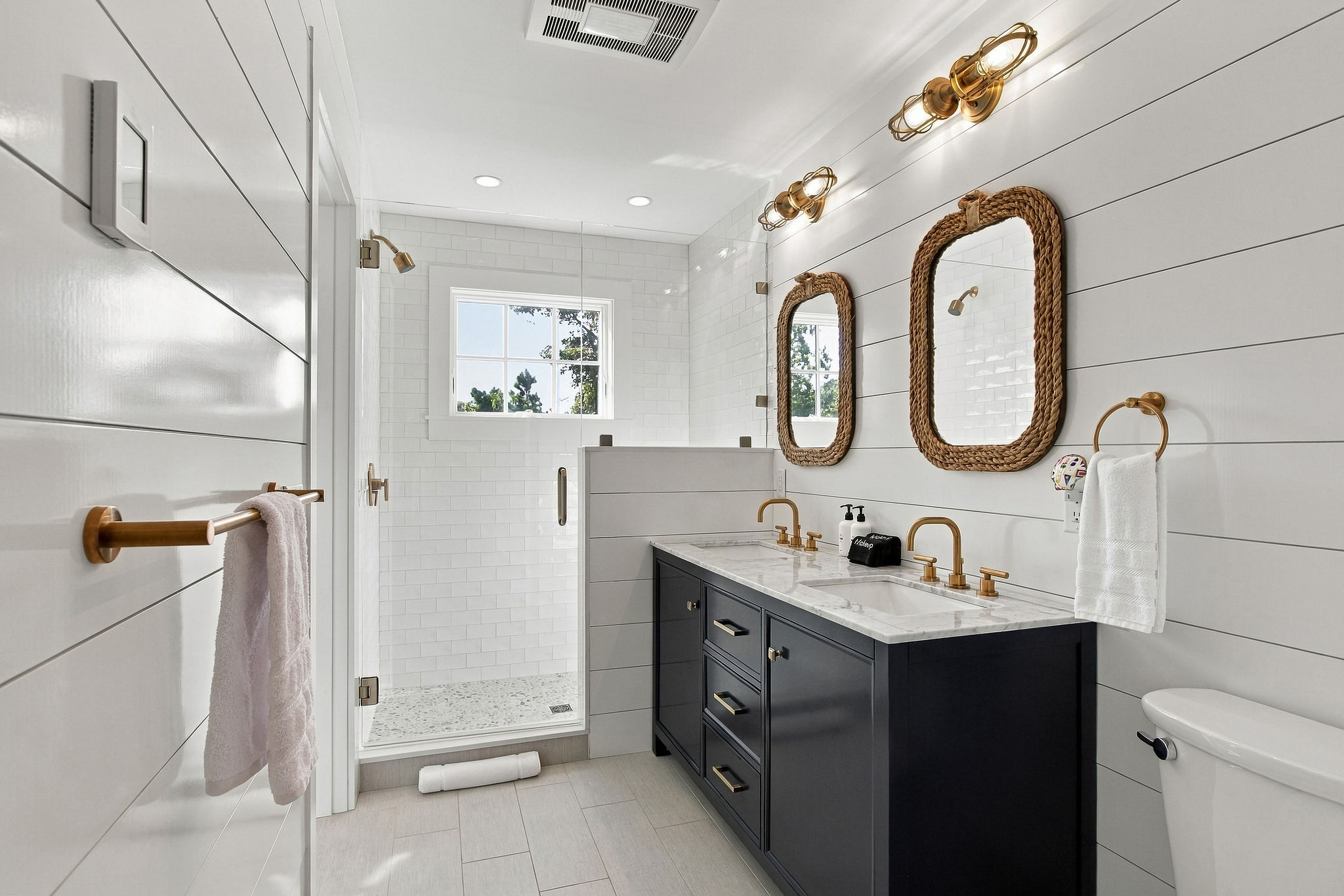 Bright spa-style bath with double vanity and walk-in glass shower