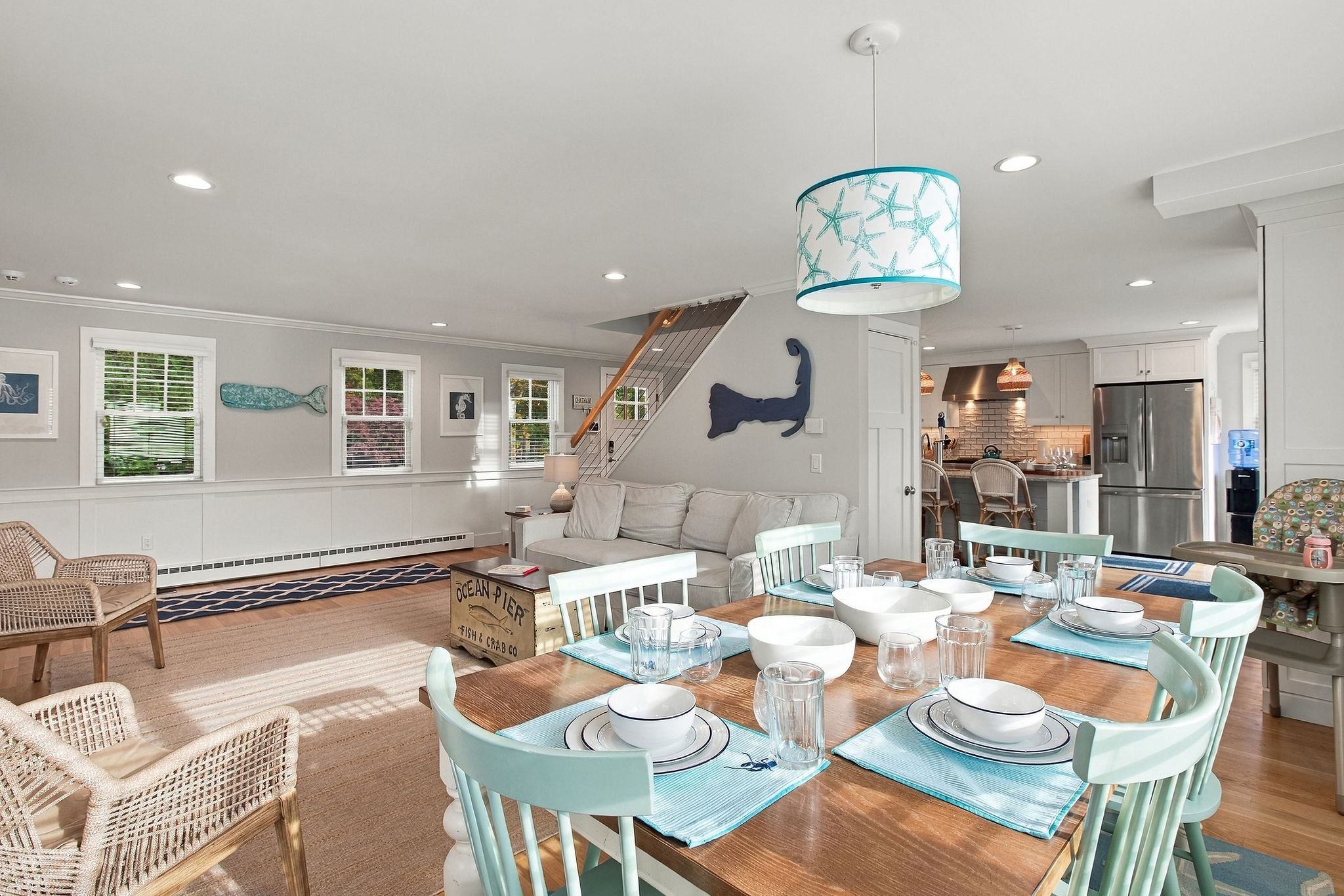 Bright coastal living space with open dining, comfy seating, and modern kitchen