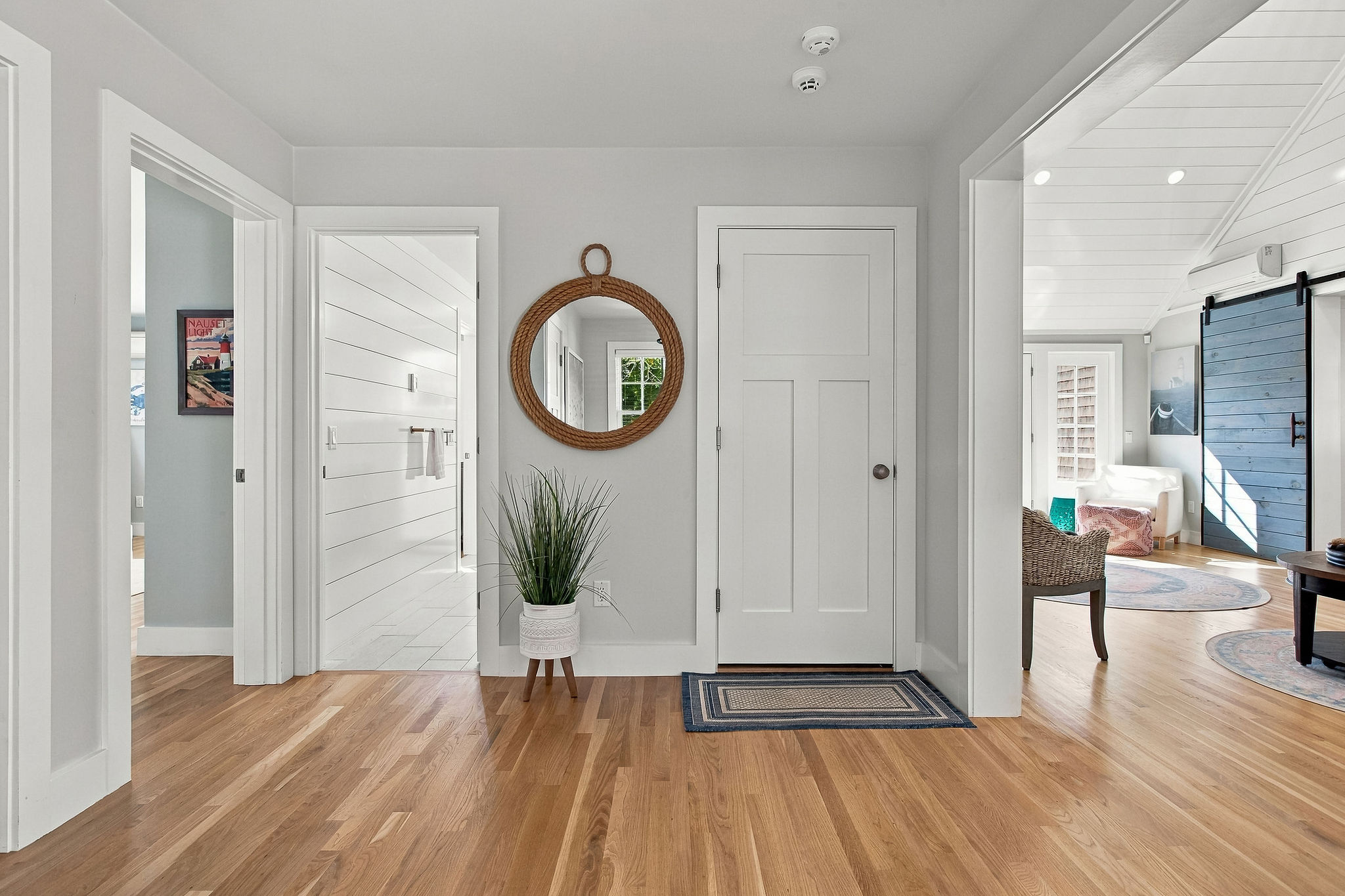 Bright coastal entryway with hardwood floors and airy open flow
