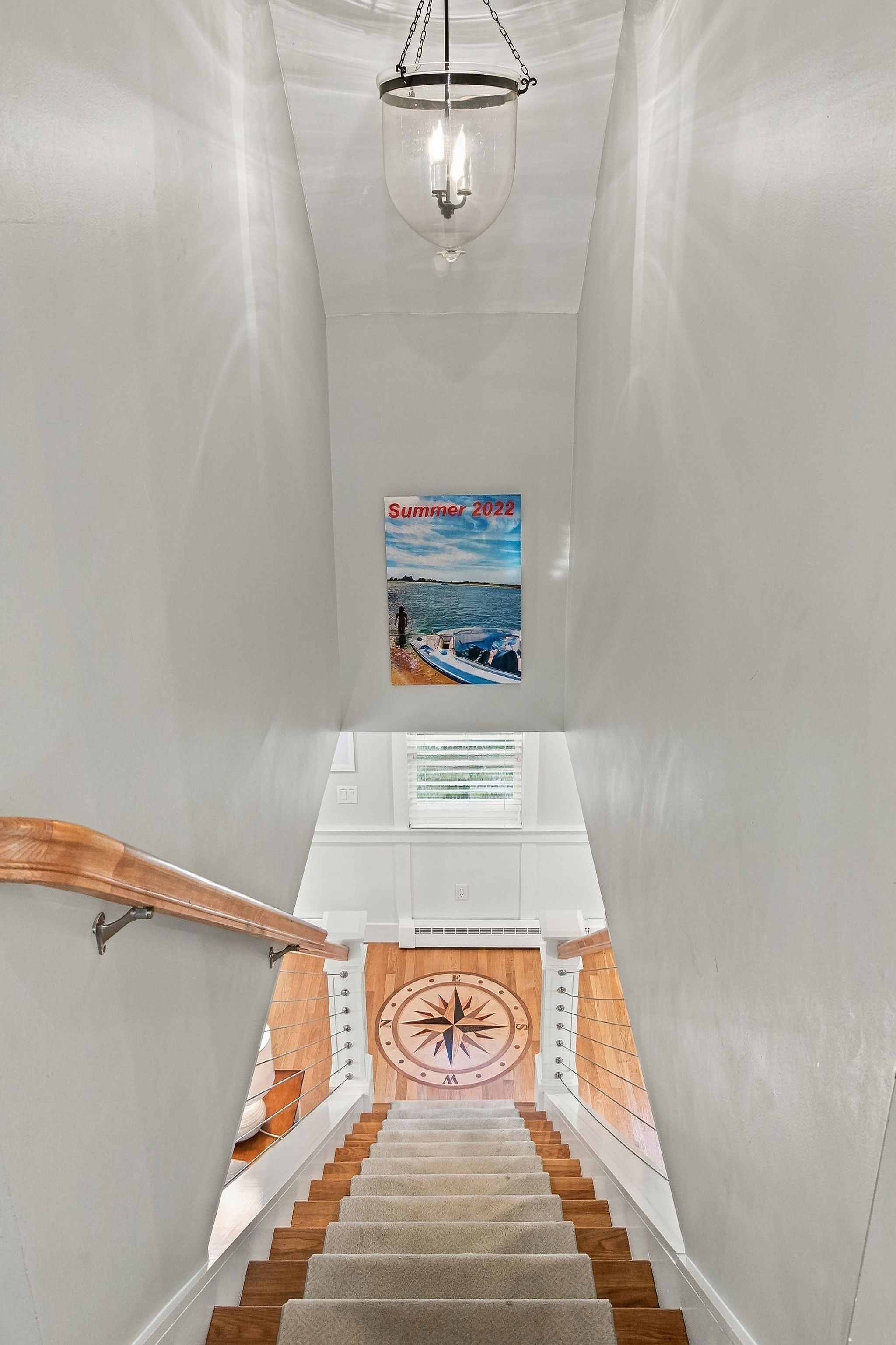 Bright coastal stairwell with elegant lighting and nautical charm