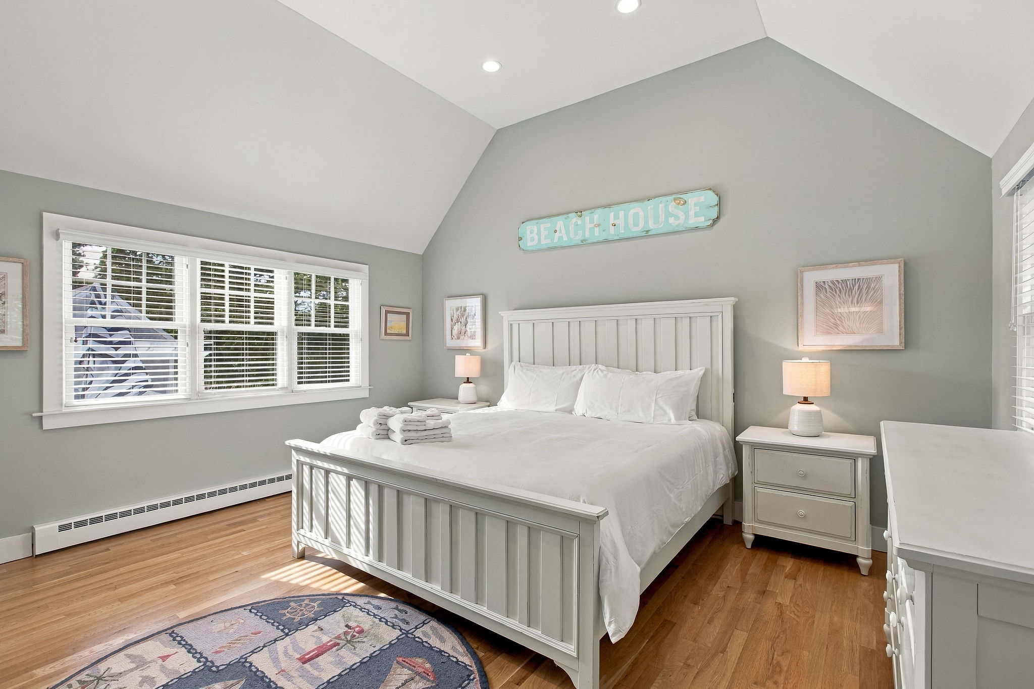 Bright coastal bedroom with vaulted ceilings and plenty of natural light