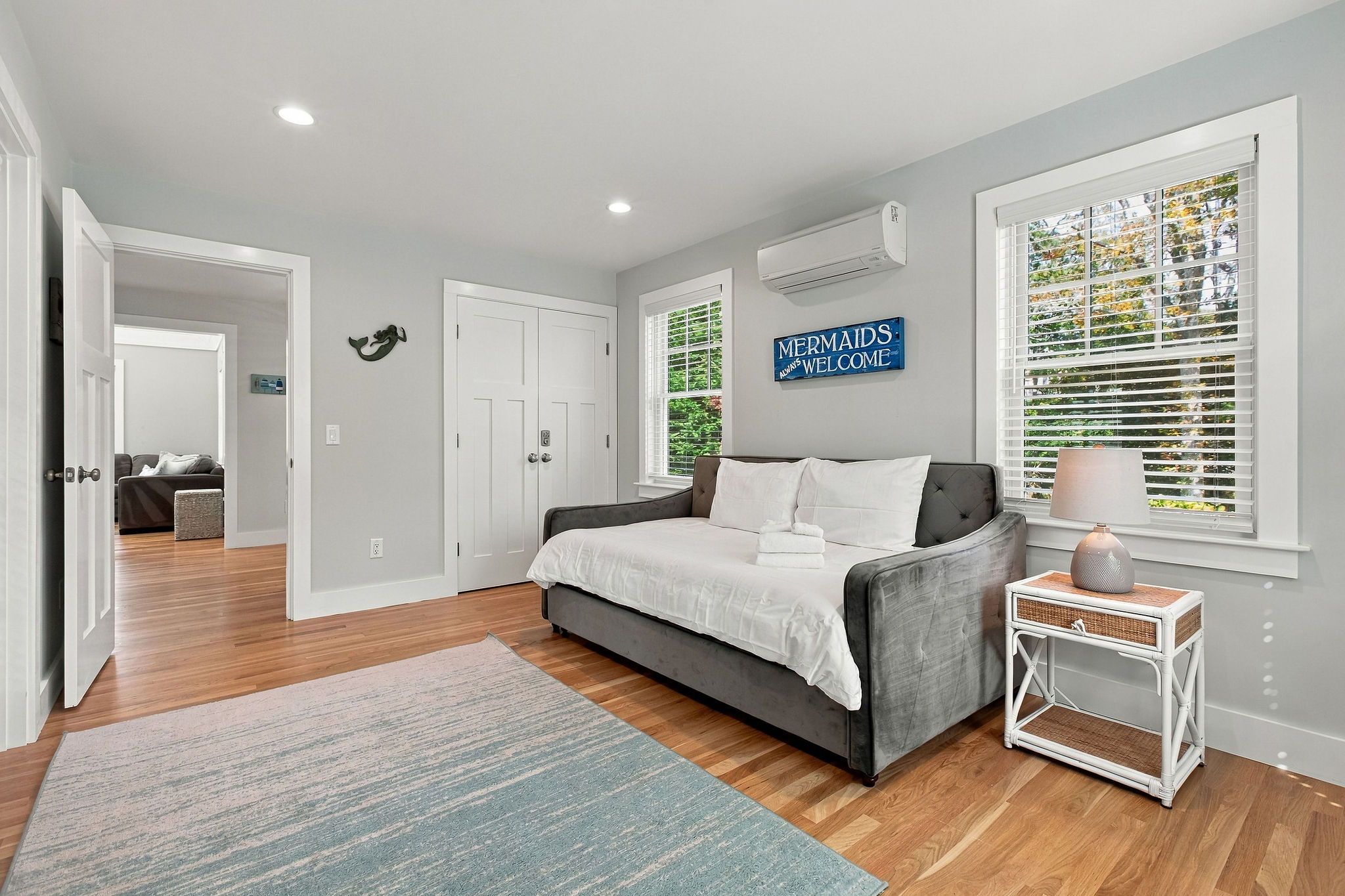 Bright coastal bedroom with daybed, hardwood floors, and natural light