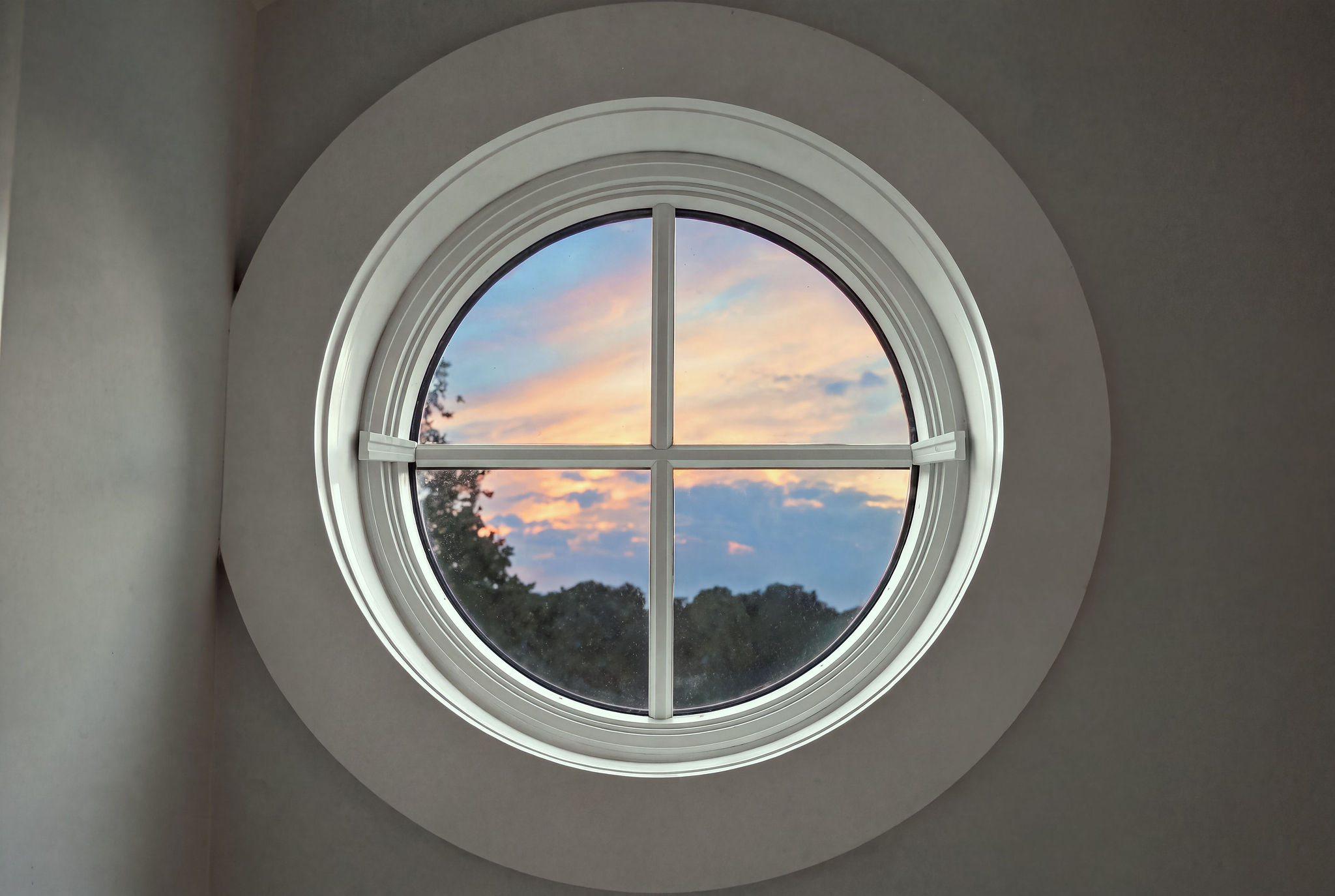 Charming round window framing serene sunset views
