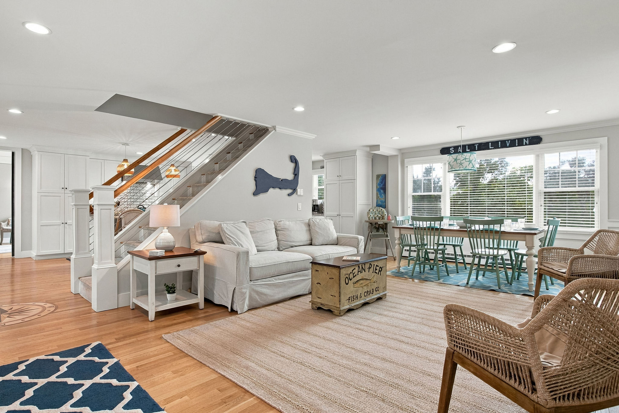 Bright coastal living space with open dining area and sunny windows