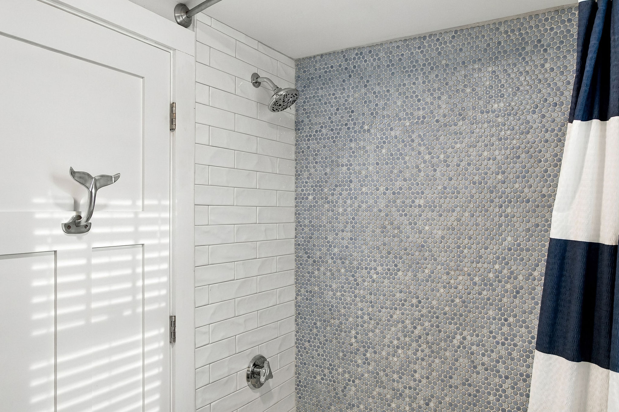 Stylish tiled shower with coastal blue mosaic accents