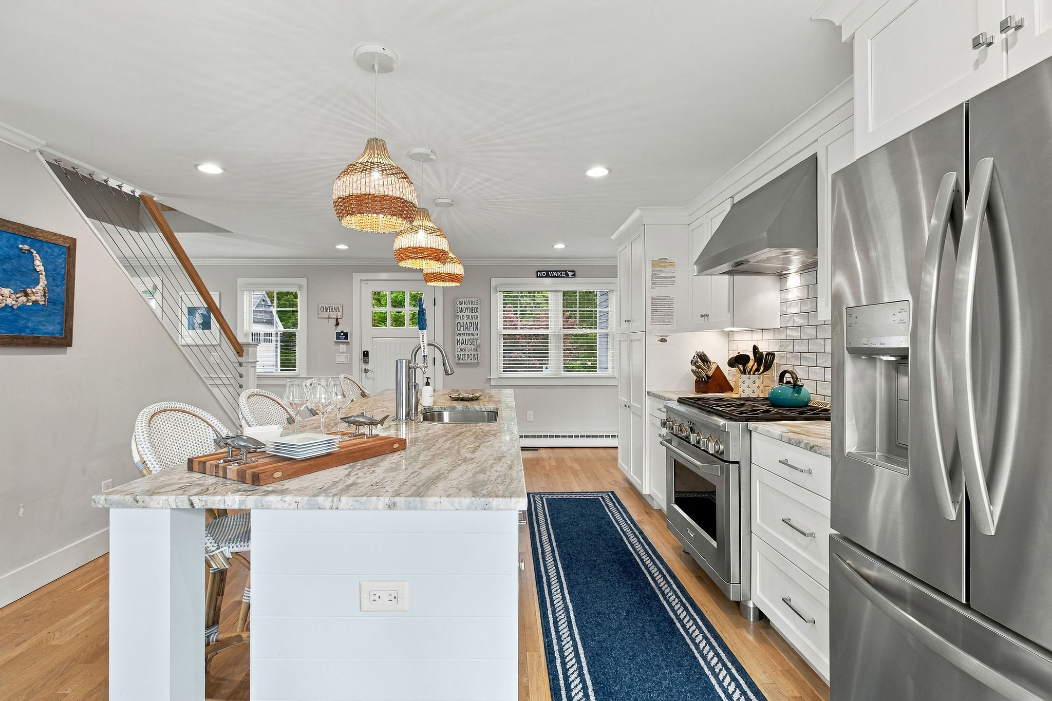 Bright coastal kitchen with island seating and sleek stainless appliances