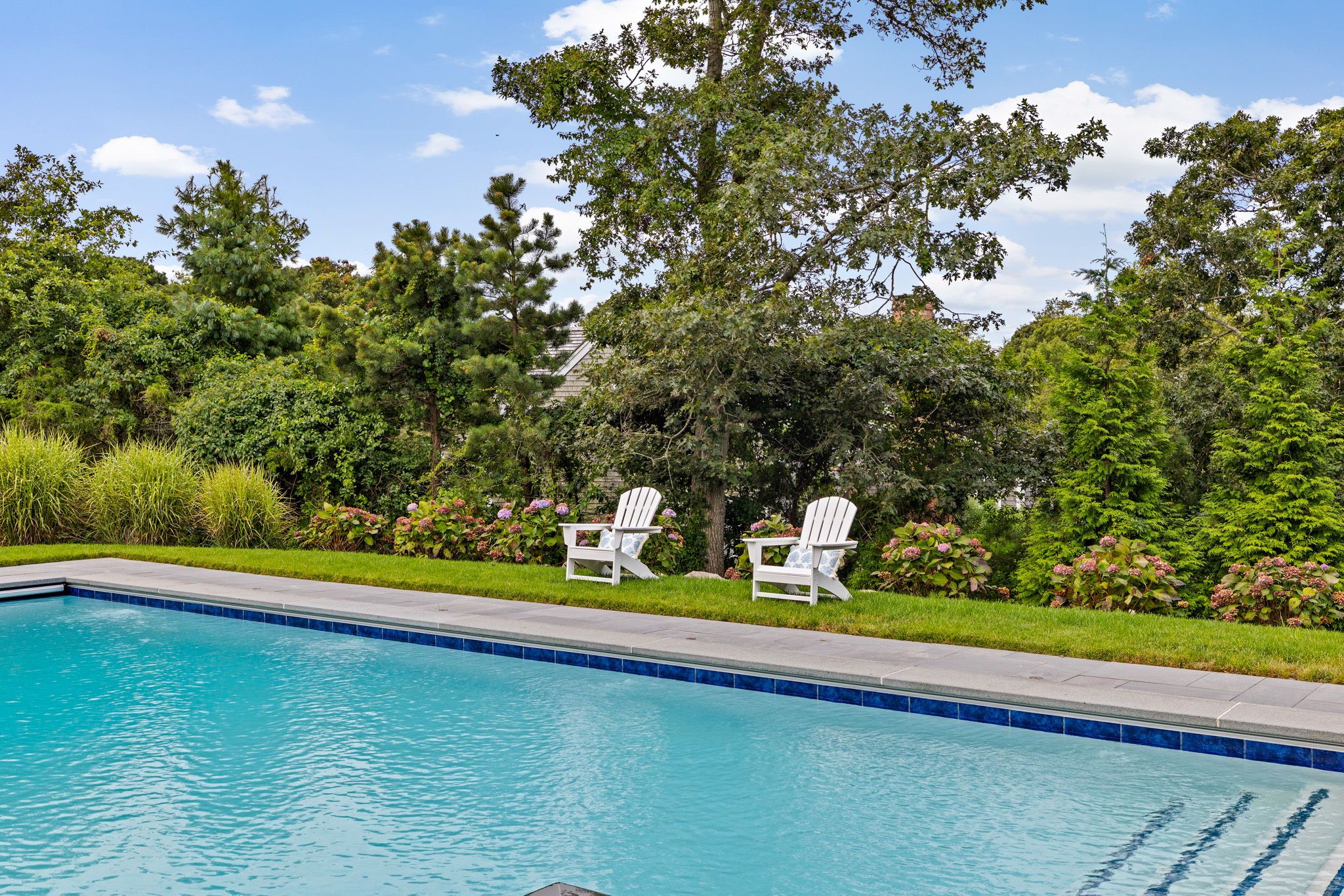 Expansive patio with poolside lounging, dining, and gathering areas.