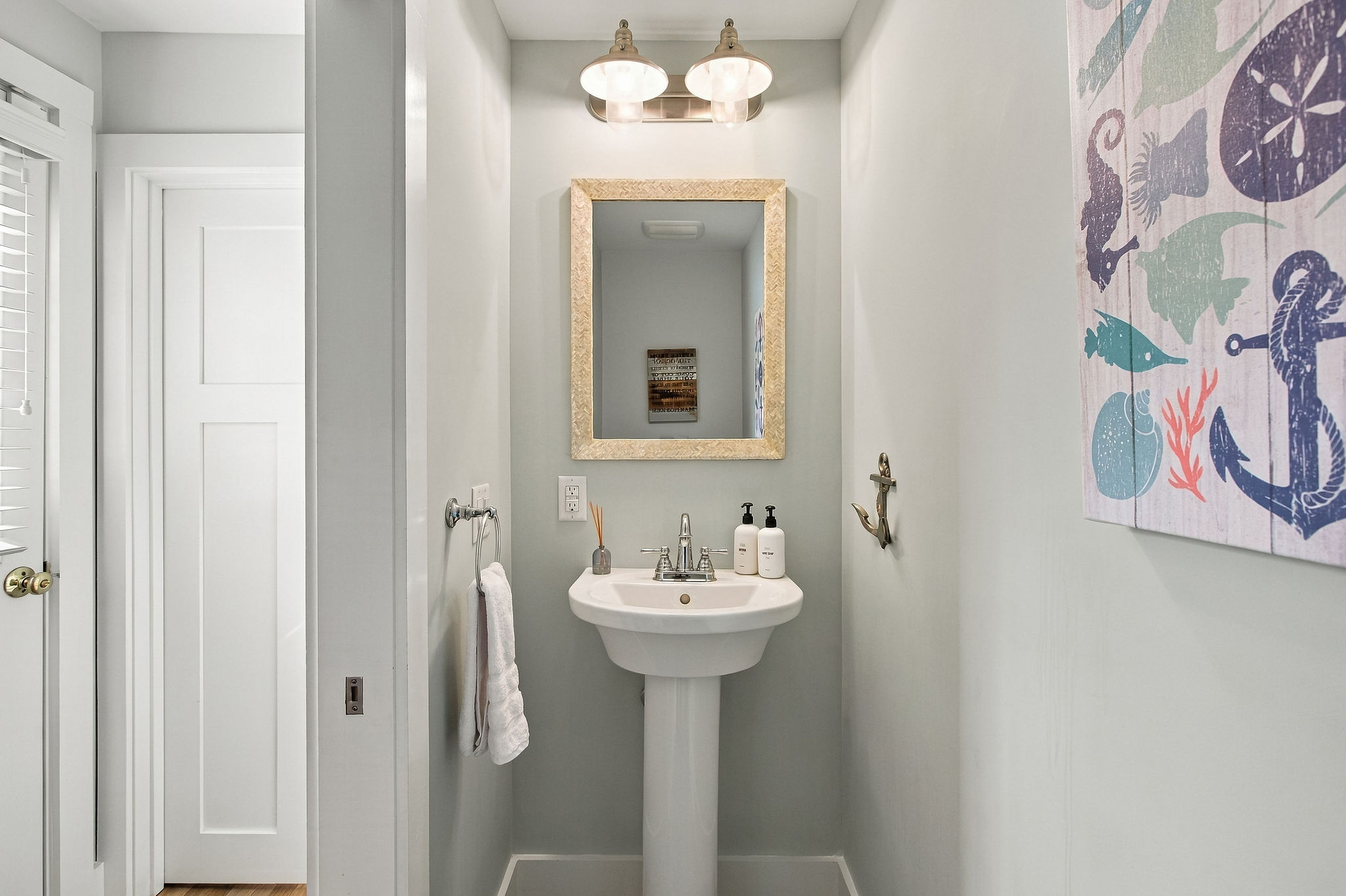 Bright coastal powder room with stylish finishes and fresh beach decor