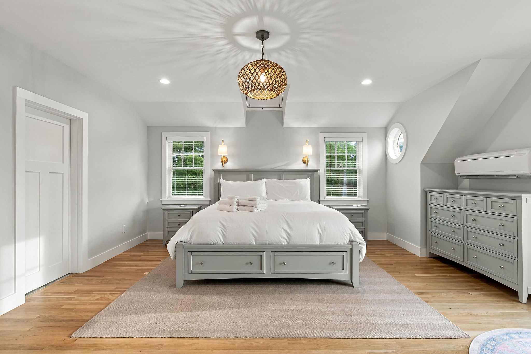 Bright, elegant bedroom with king bed, hardwood floors, and serene style