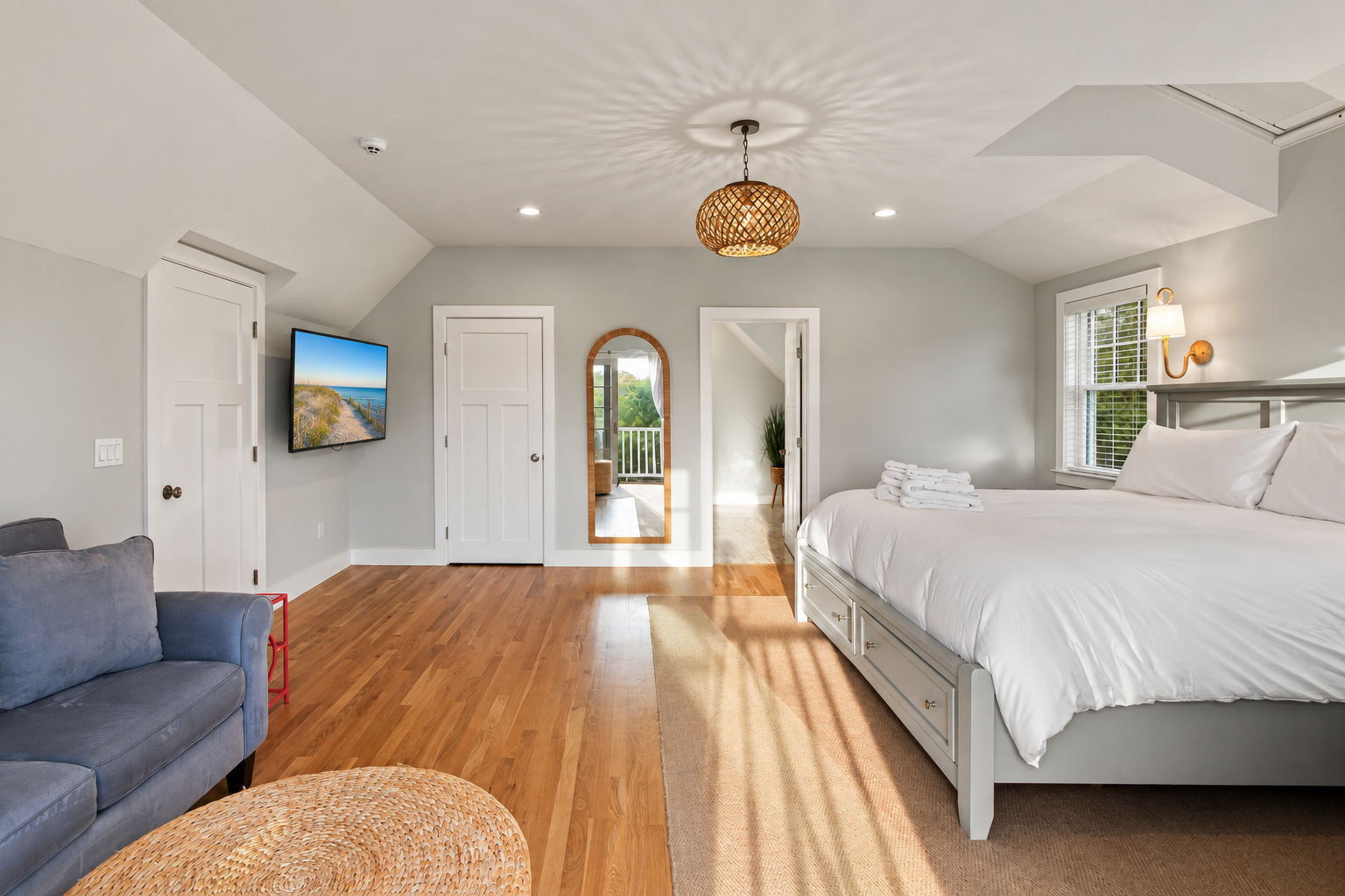 Bright, spacious bedroom with hardwood floors and cozy seating
