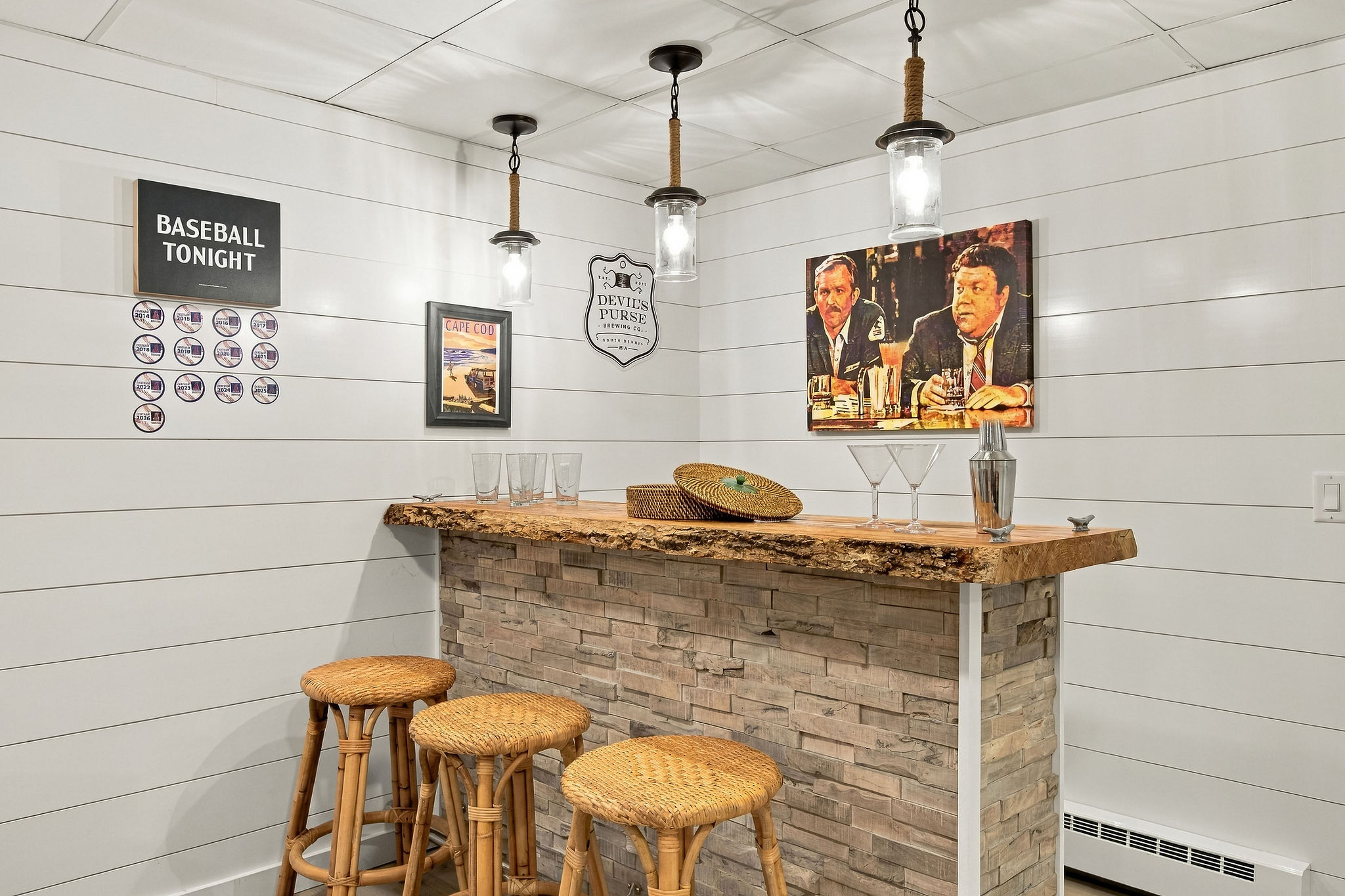 Cozy home bar with pendant lighting, stone accents, and stylish seating