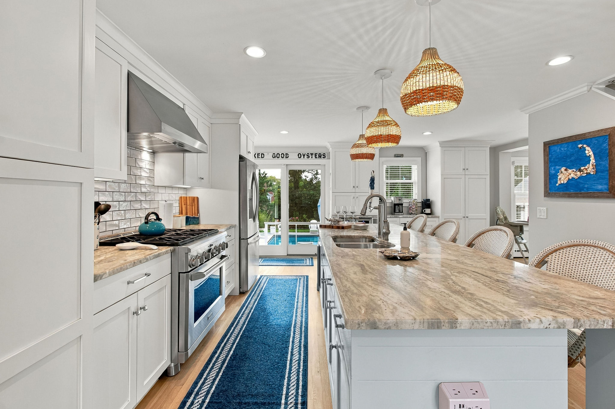 Bright coastal kitchen with large island and pool-view patio access