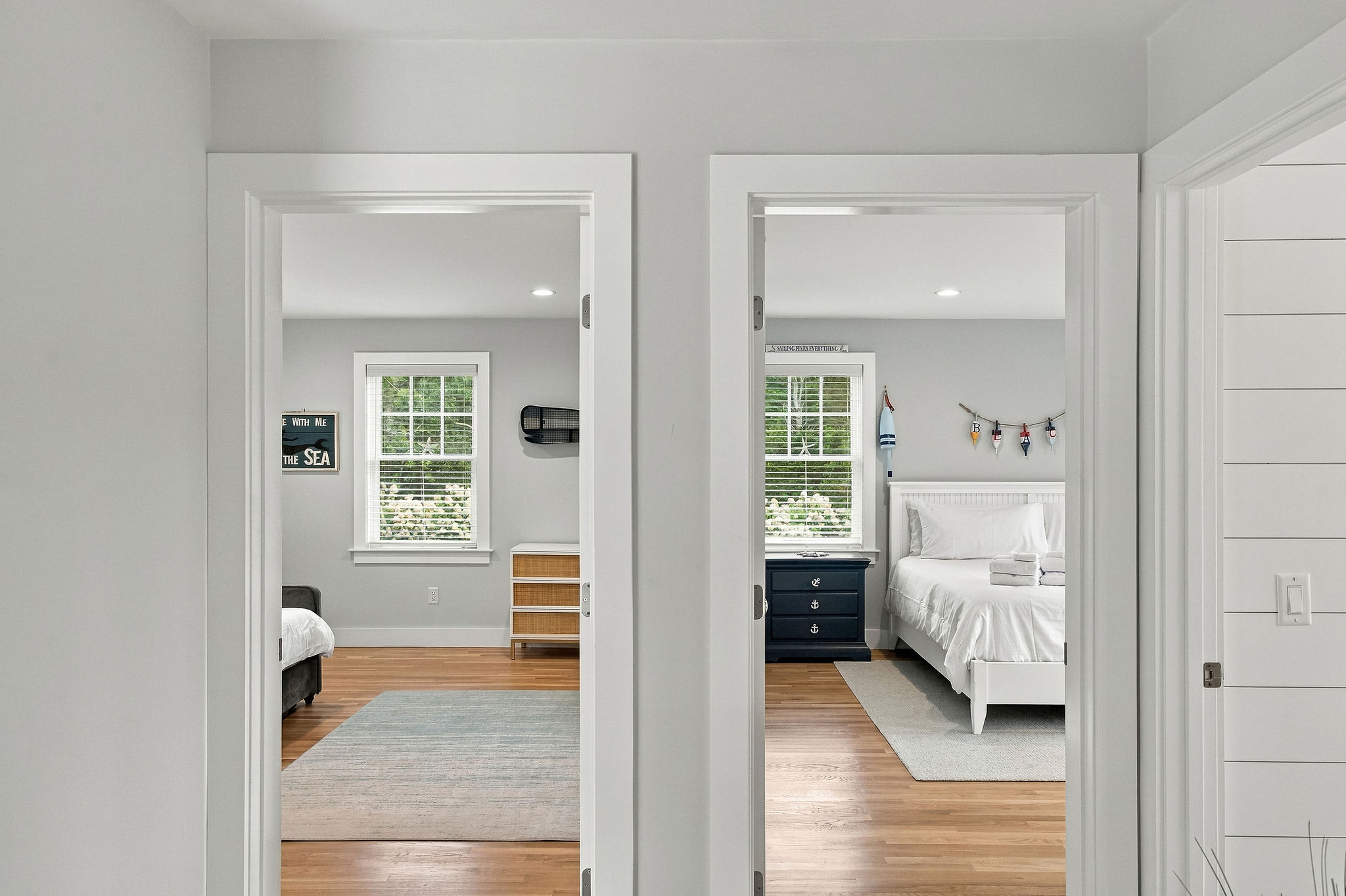 Bright hallway leading to two airy, coastal-inspired bedrooms