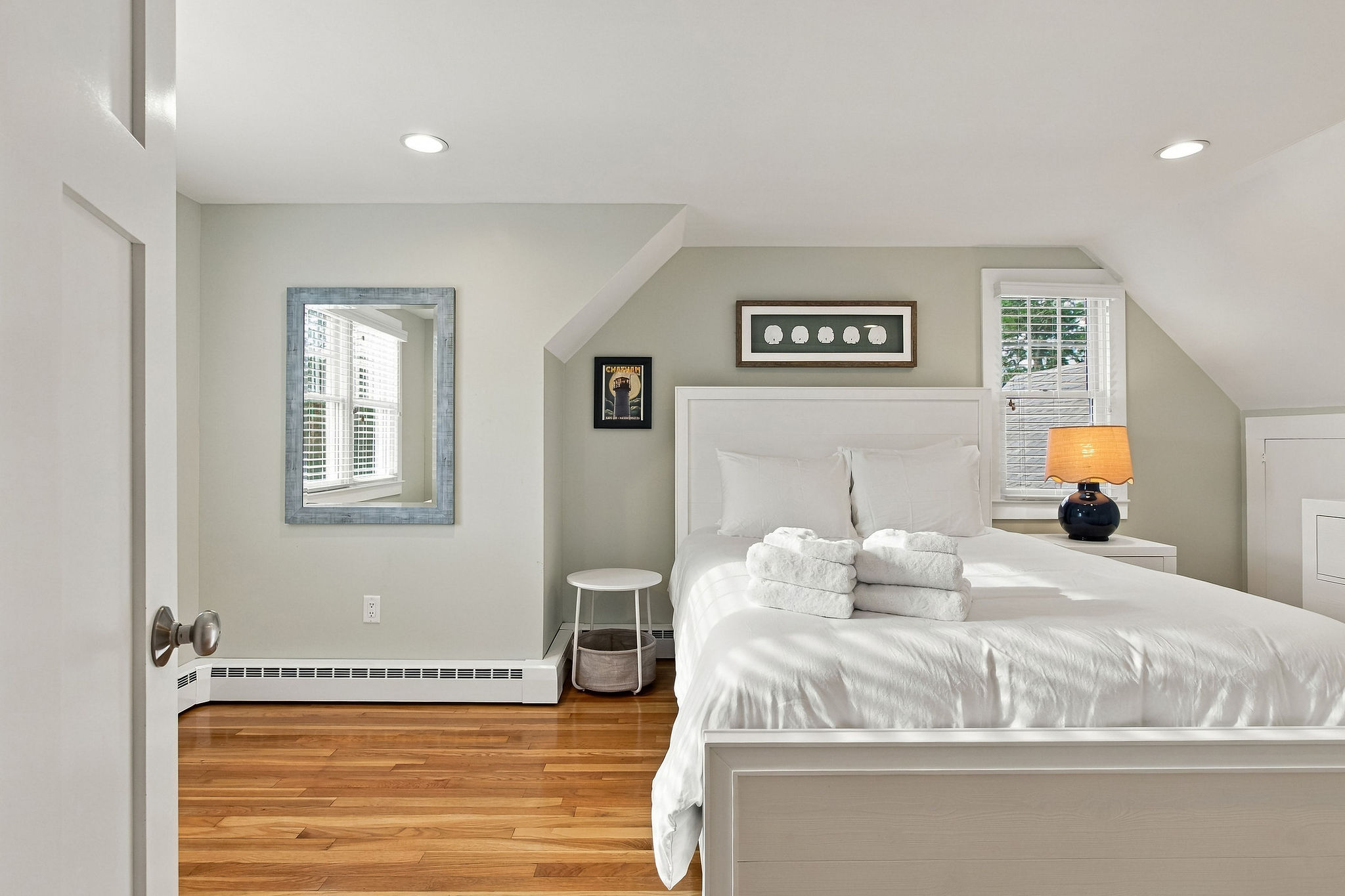 Bright, cozy bedroom with hardwood floors and abundant natural light