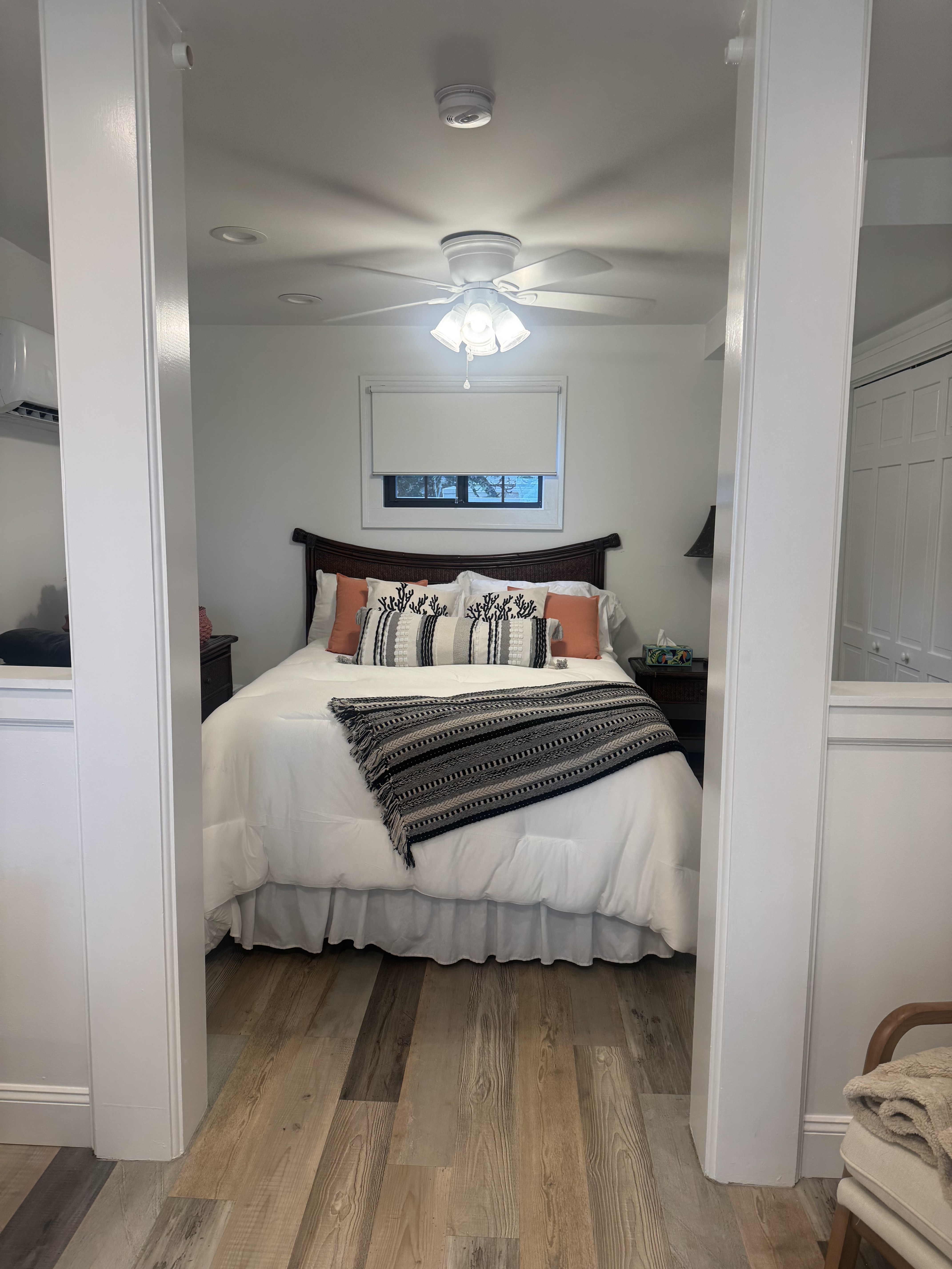 Bright, cozy bedroom with plush linens, warm floors, and a relaxing feel
