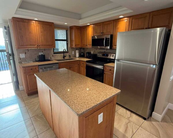 Spacious kitchen with island, stainless appliances, and warm wood cabinetry