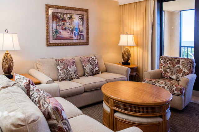 Cozy tropical-style living room with balcony access and plenty of seating