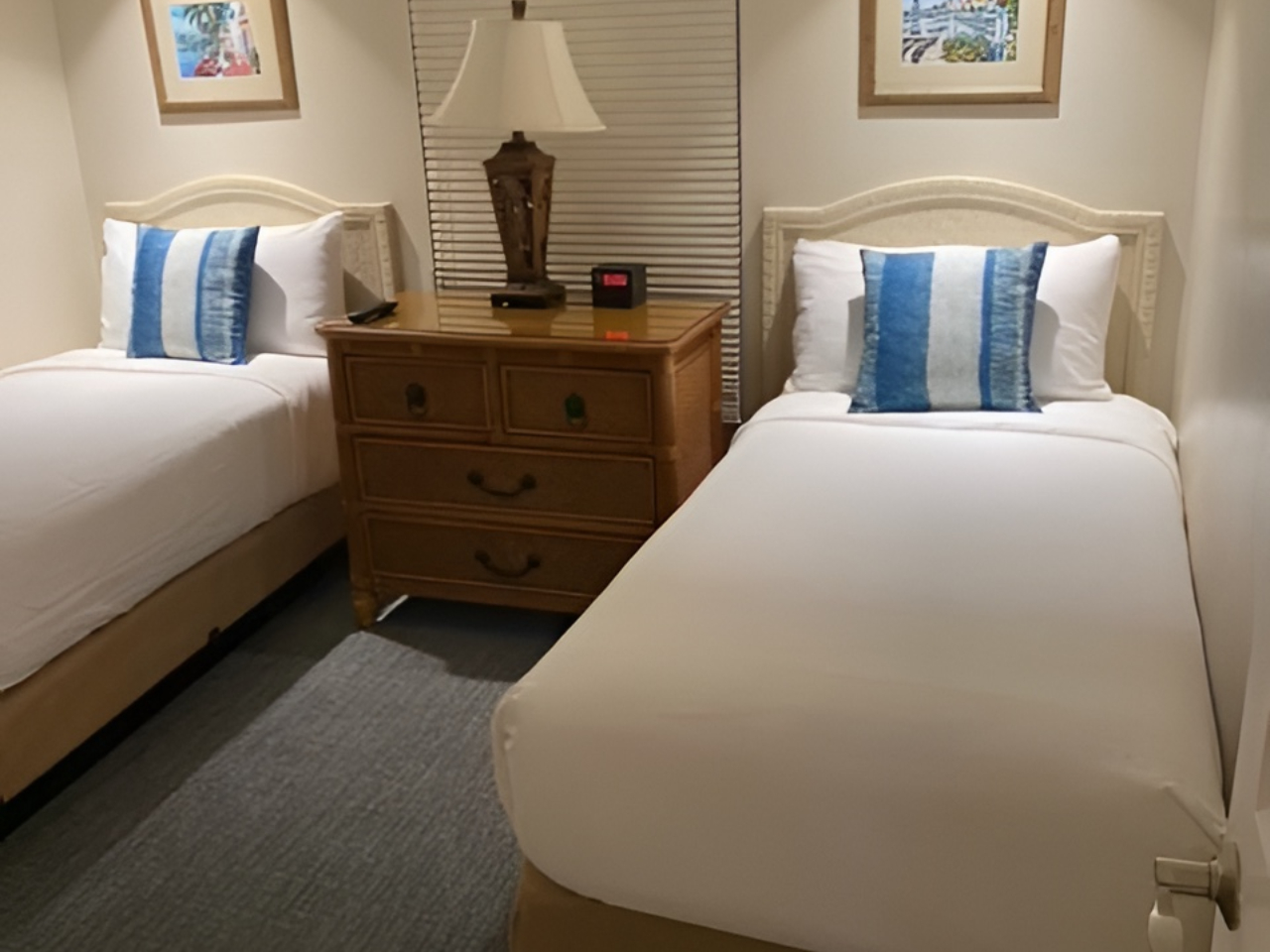 Cozy twin bedroom with warm lighting and a convenient shared nightstand
