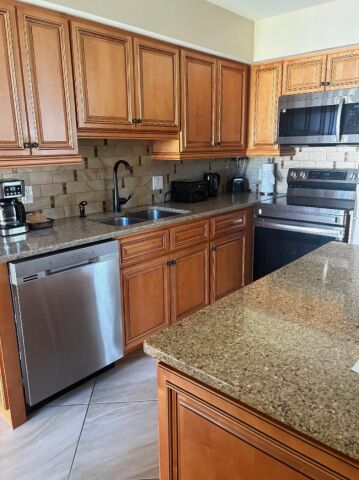 Spacious kitchen with granite counters, island, and stainless appliances