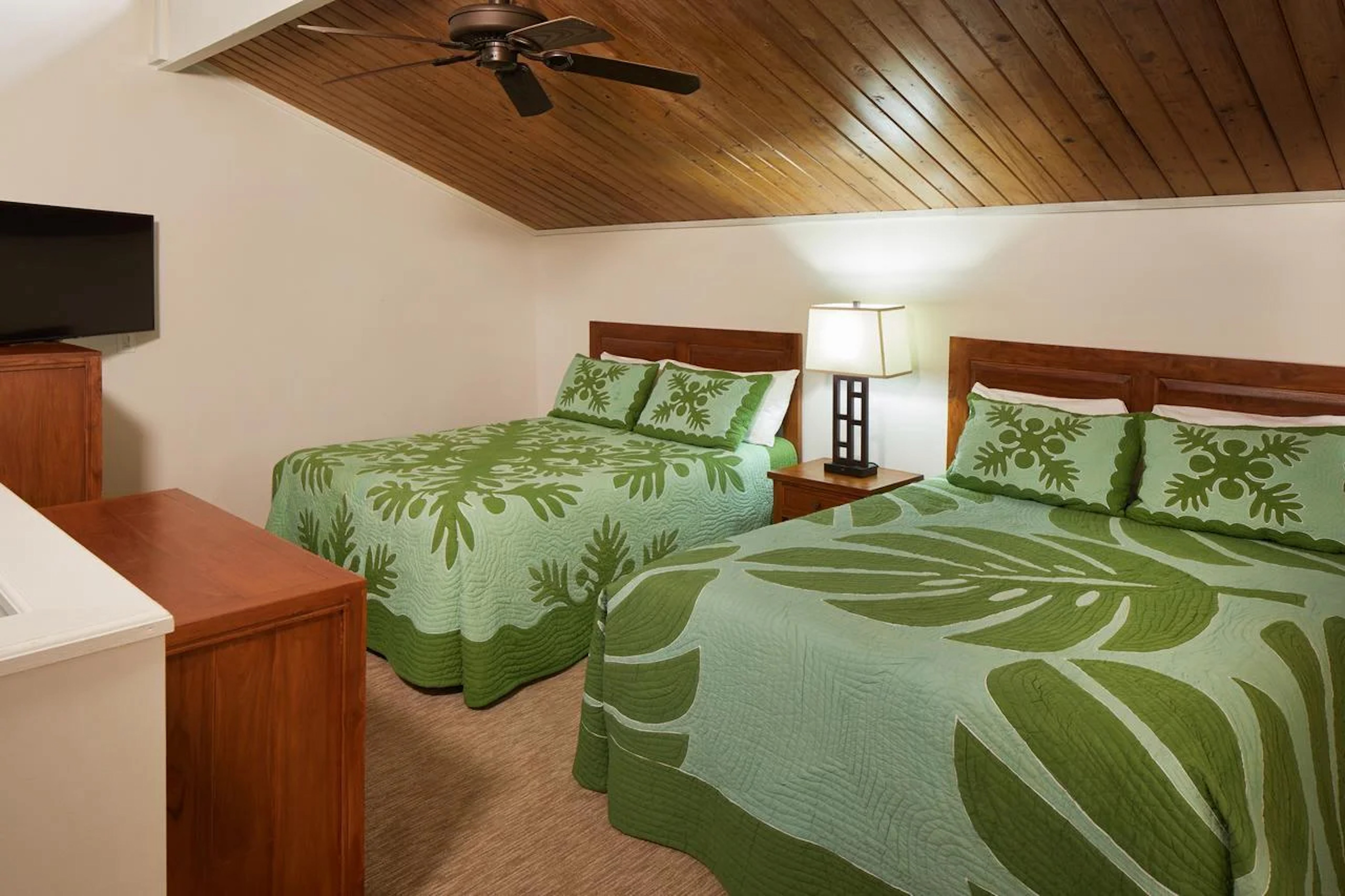 Cozy double-bed room with tropical decor and warm wood-paneled ceiling