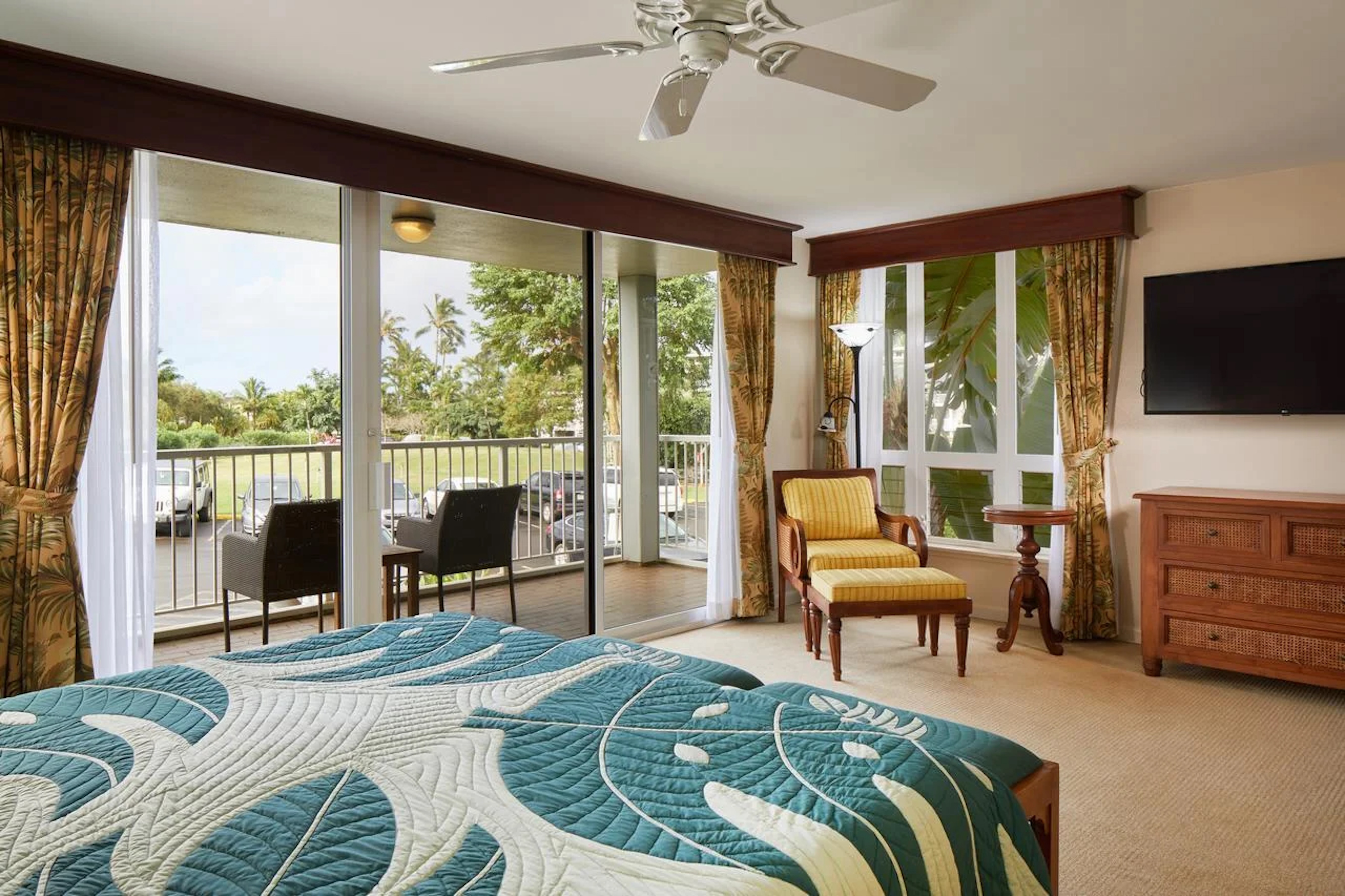 Bright tropical bedroom with private balcony and lush outdoor views