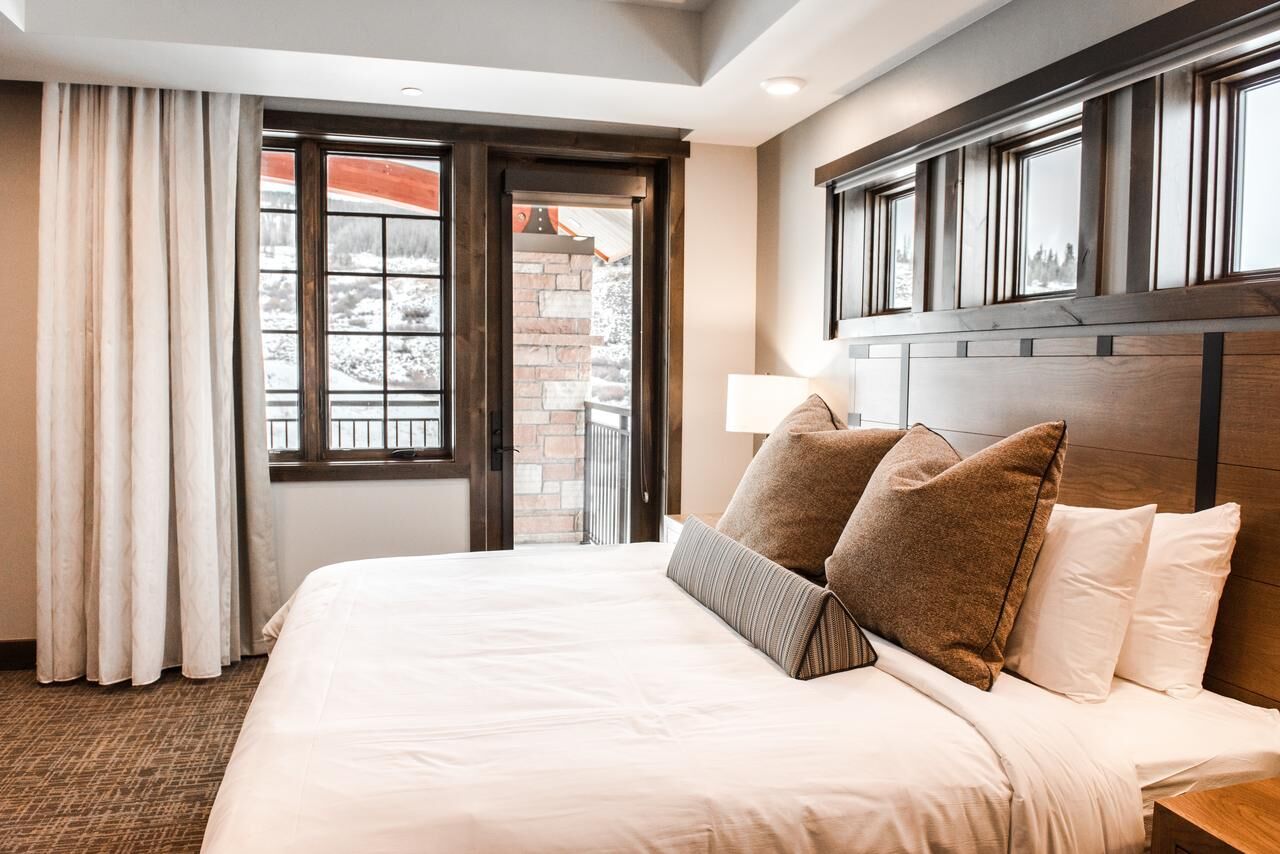 Cozy king bedroom with warm wood accents and private balcony access