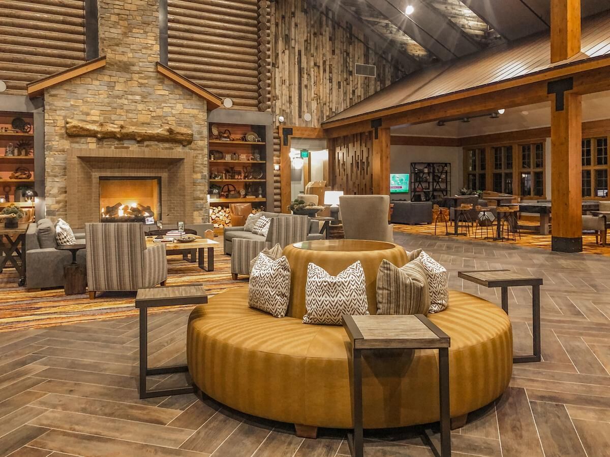 Warm lodge-style lounge with stone fireplace and inviting rustic seating