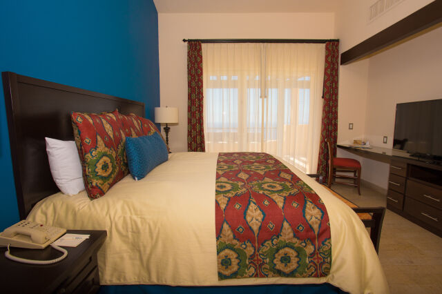 Bright, stylish bedroom with a king bed, desk area, and soft natural light