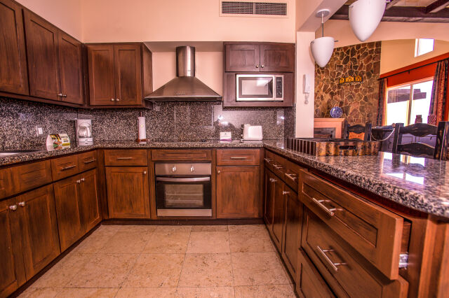 Spacious gourmet kitchen with granite counters and warm wood finishes
