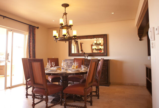 Elegant dining room with chandelier, seating for 6, and sunny patio access