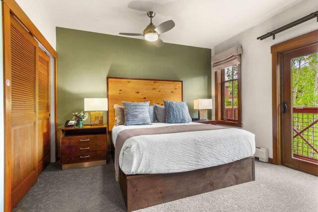 Cozy bedroom with wood accents, natural light, and balcony access