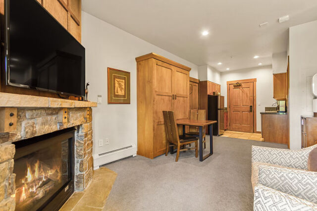 Cozy lodge-style studio with fireplace, TV, and rustic mountain charm
