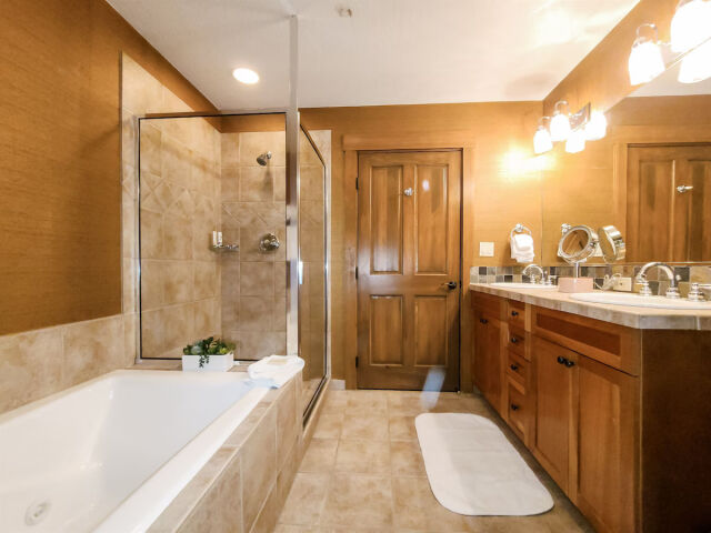 Spa-like bathroom with soaking tub, glass shower, and double vanity