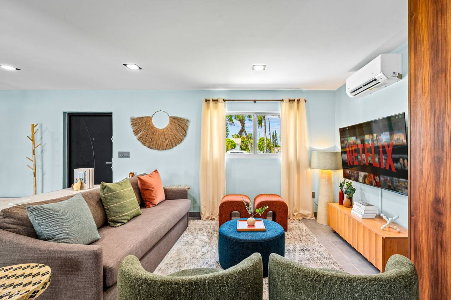 Relax in the spacious and comfortable living room, featuring cozy seating, a TV, and plenty of natural light. It’s the perfect spot to unwind, enjoy a movie, or spend quality time with family and friends.