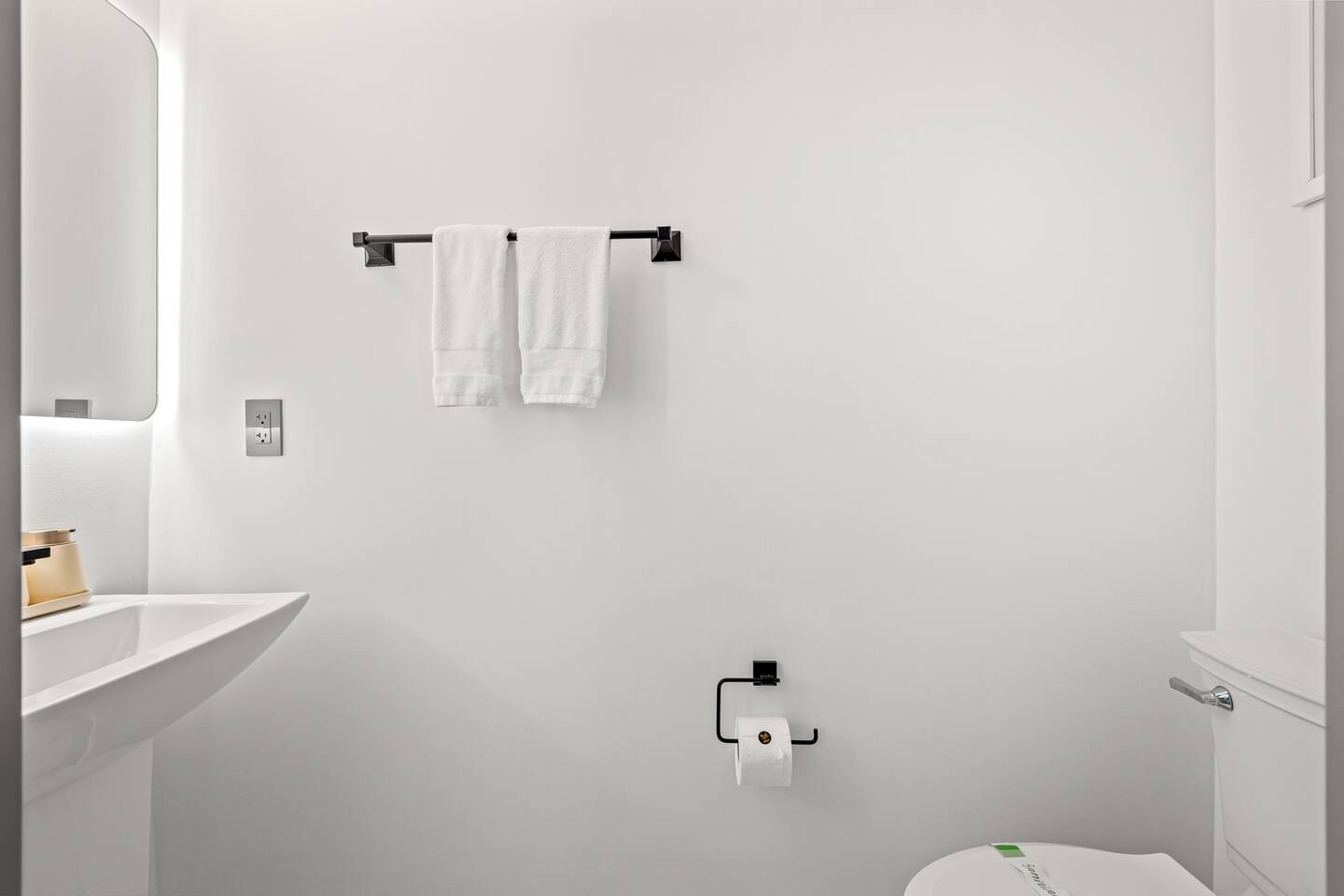 This modern half bathroom features a toilet and vanity
