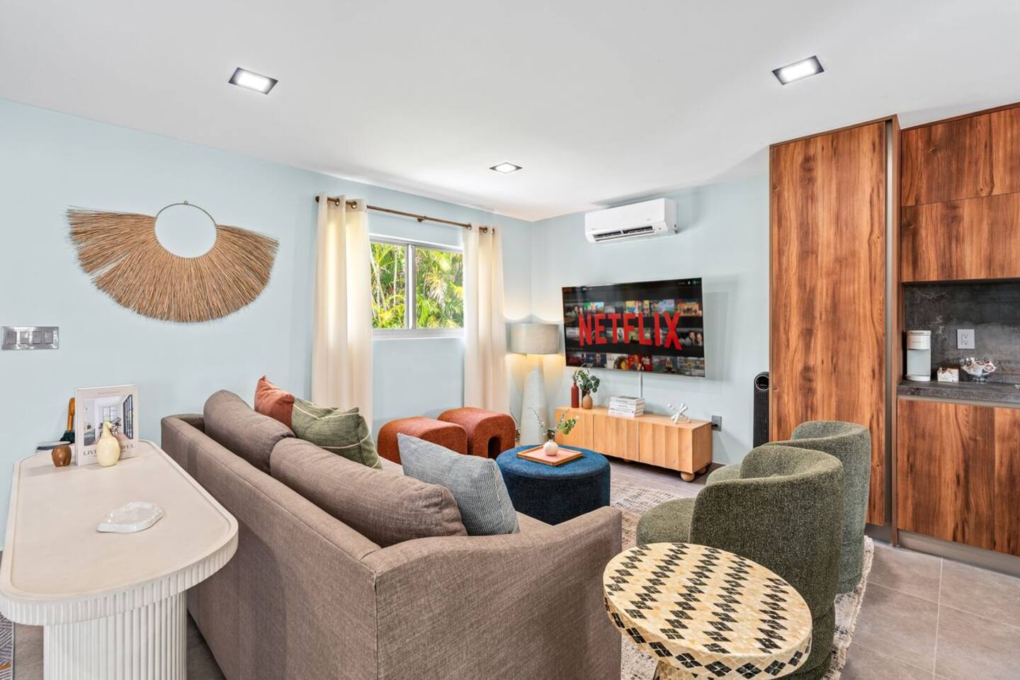 Soft furnishings paired with bright pops of color give the space a fresh and cheerful feel, while keeping it warm and inviting throughout.