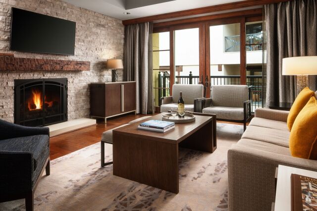 Cozy luxe living room with fireplace, balcony, and stylish seating