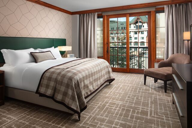 Bright, elegant bedroom with balcony views and cozy lounge seating