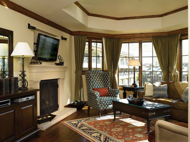 Cozy sunlit living room with fireplace, TV, and elegant seating