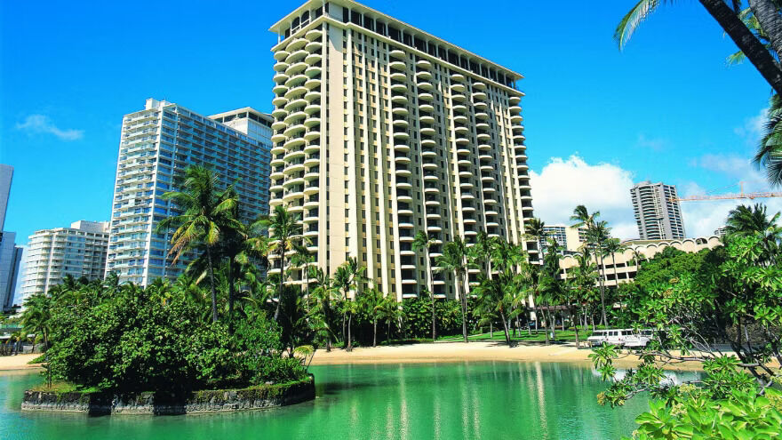 Tropical waterfront high-rise with palm-lined lagoon views