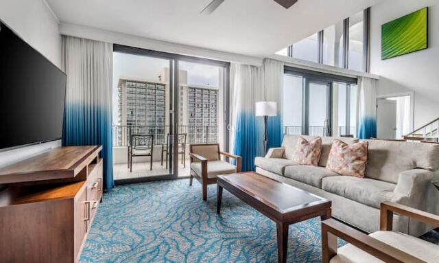 Bright vaulted living room with balcony seating and city views