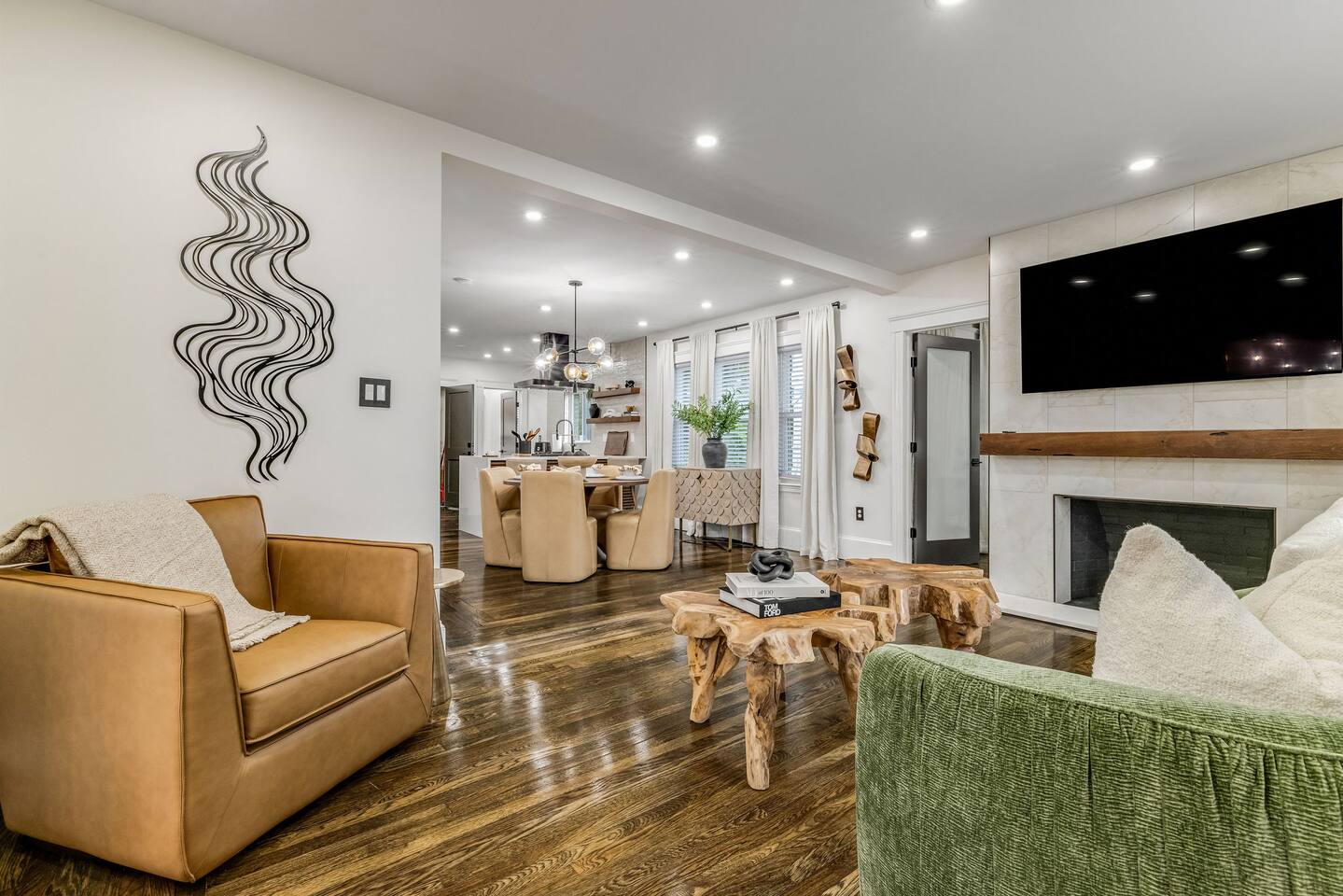 Spacious open-concept living area with designer furnishings, fireplace, and SmartTV.