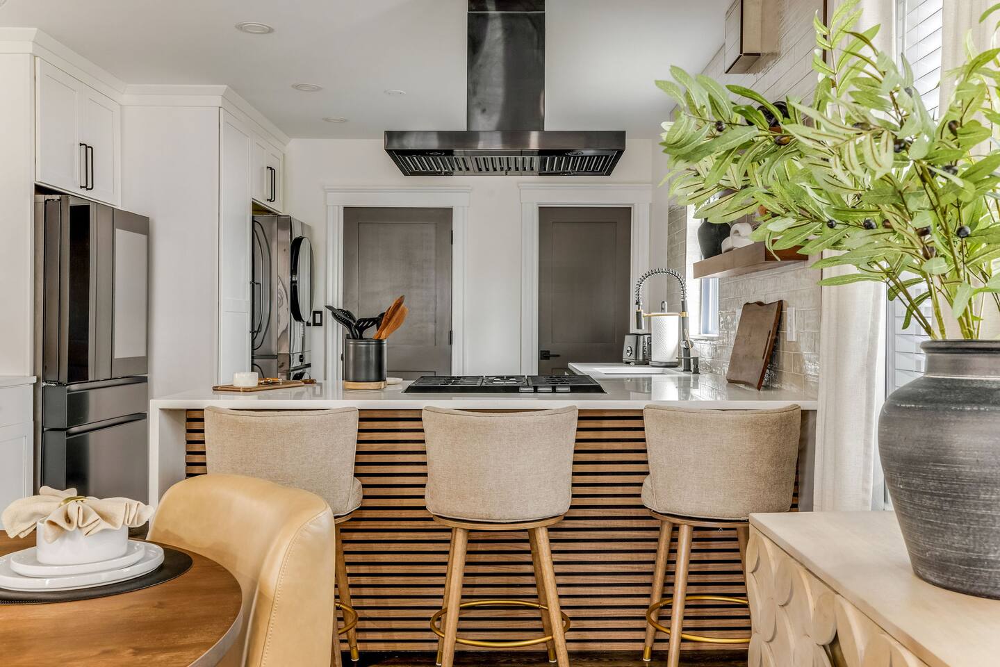 Modern kitchen with premium appliances, spacious island, and seating for three.