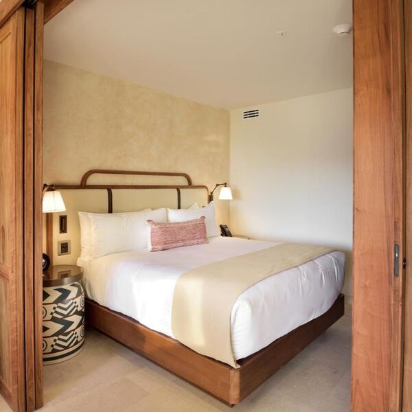 Cozy boutique-style bedroom with plush bedding and warm wood accents